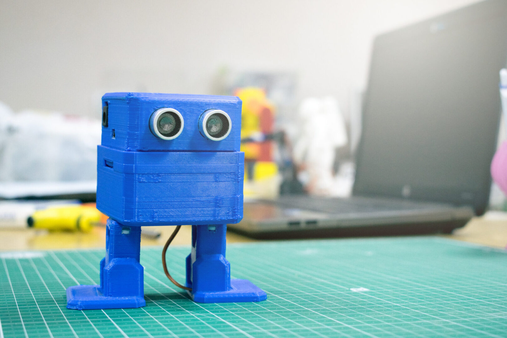 Blue robot on a green cutting mat.