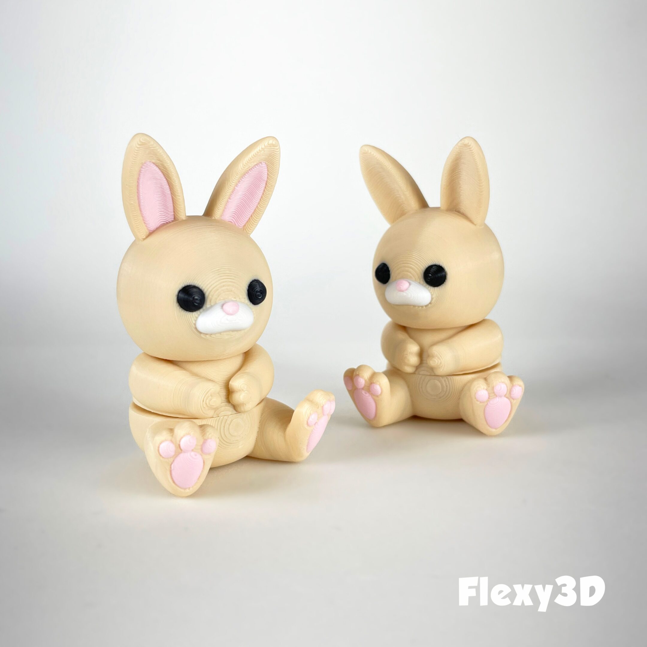Two cute bunny figurines sitting facing each other.