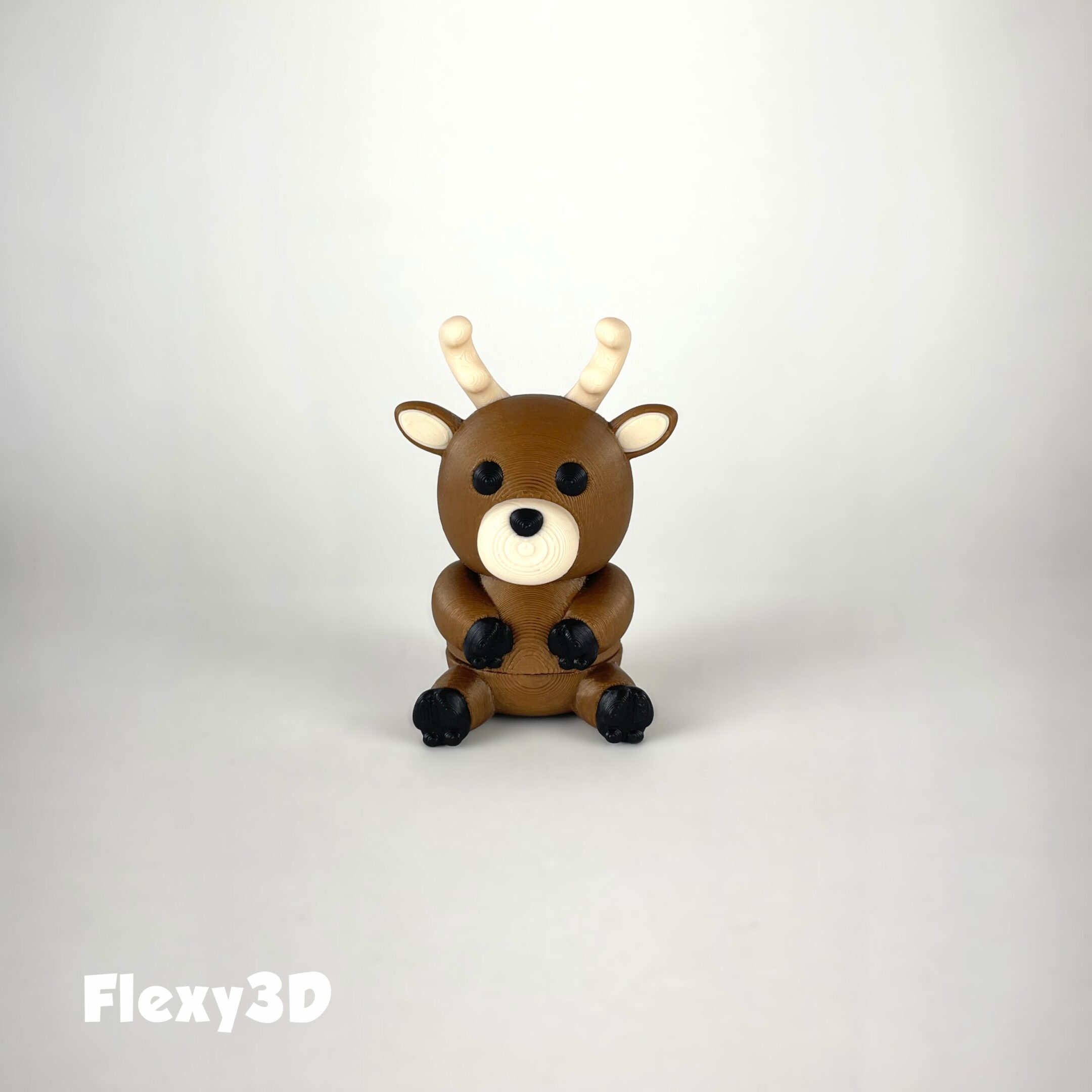 A small, cute plush reindeer with antlers sitting against a white background.