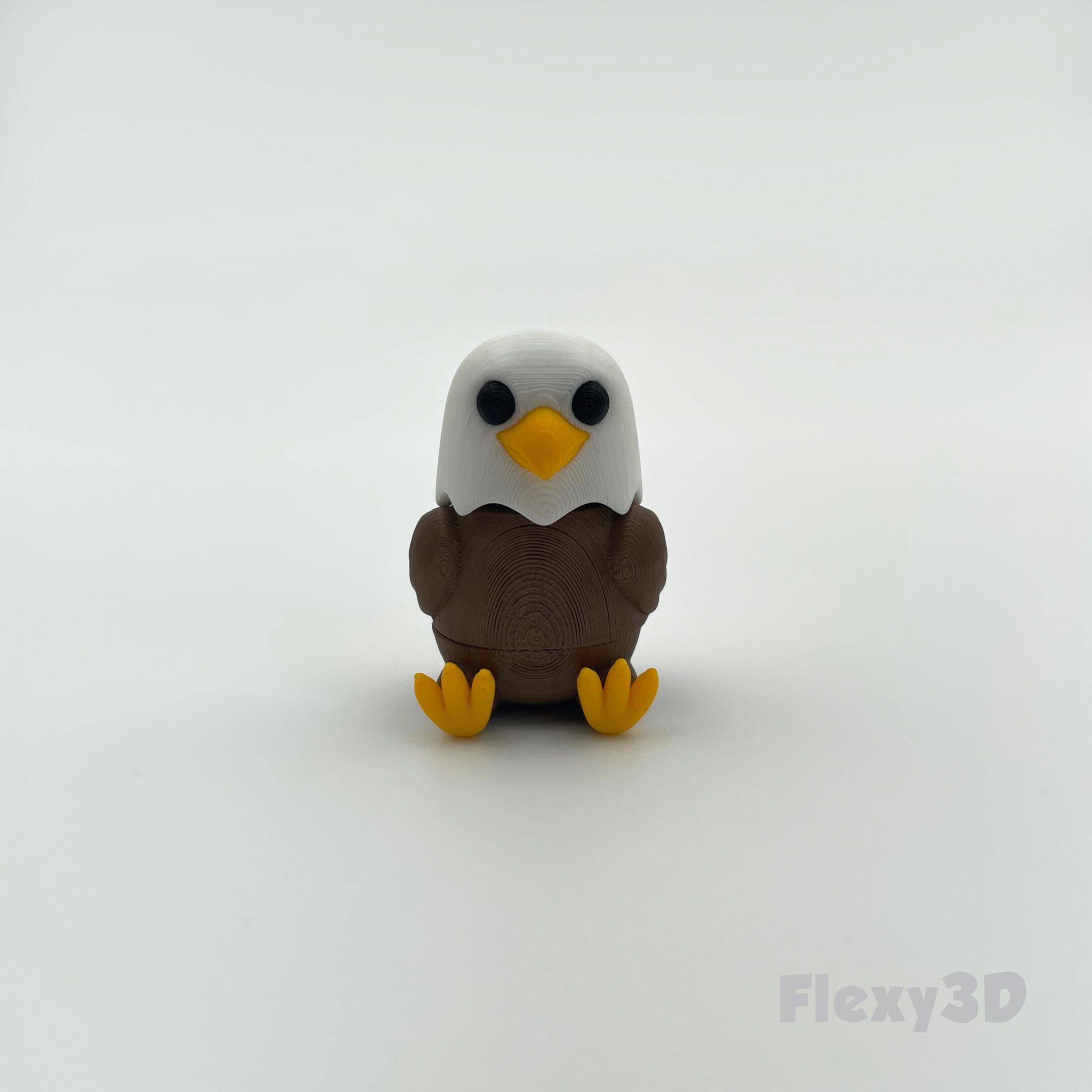 A small toy eagle with white head and brown body.