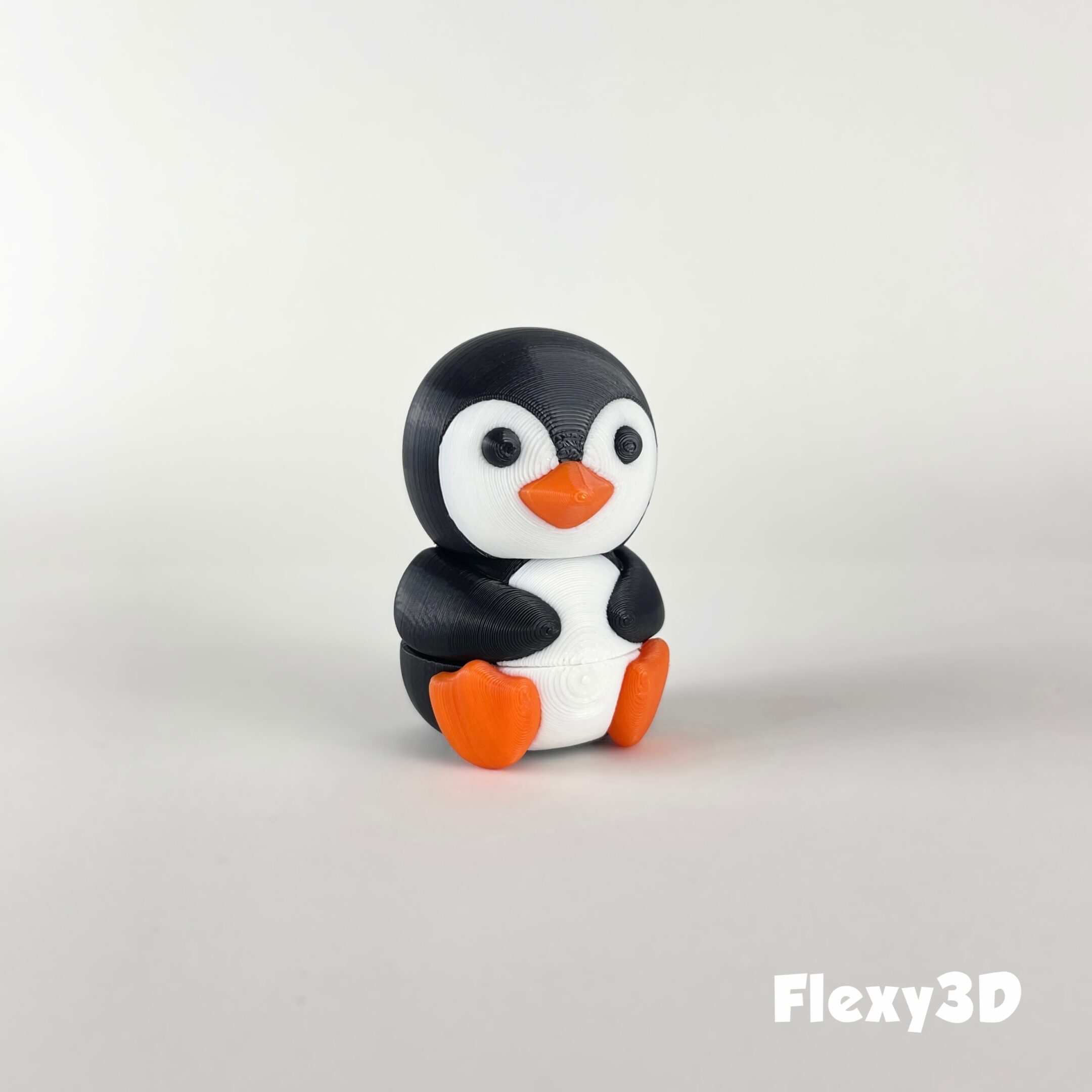 A small, cute penguin figurine with black, white, and orange colors.