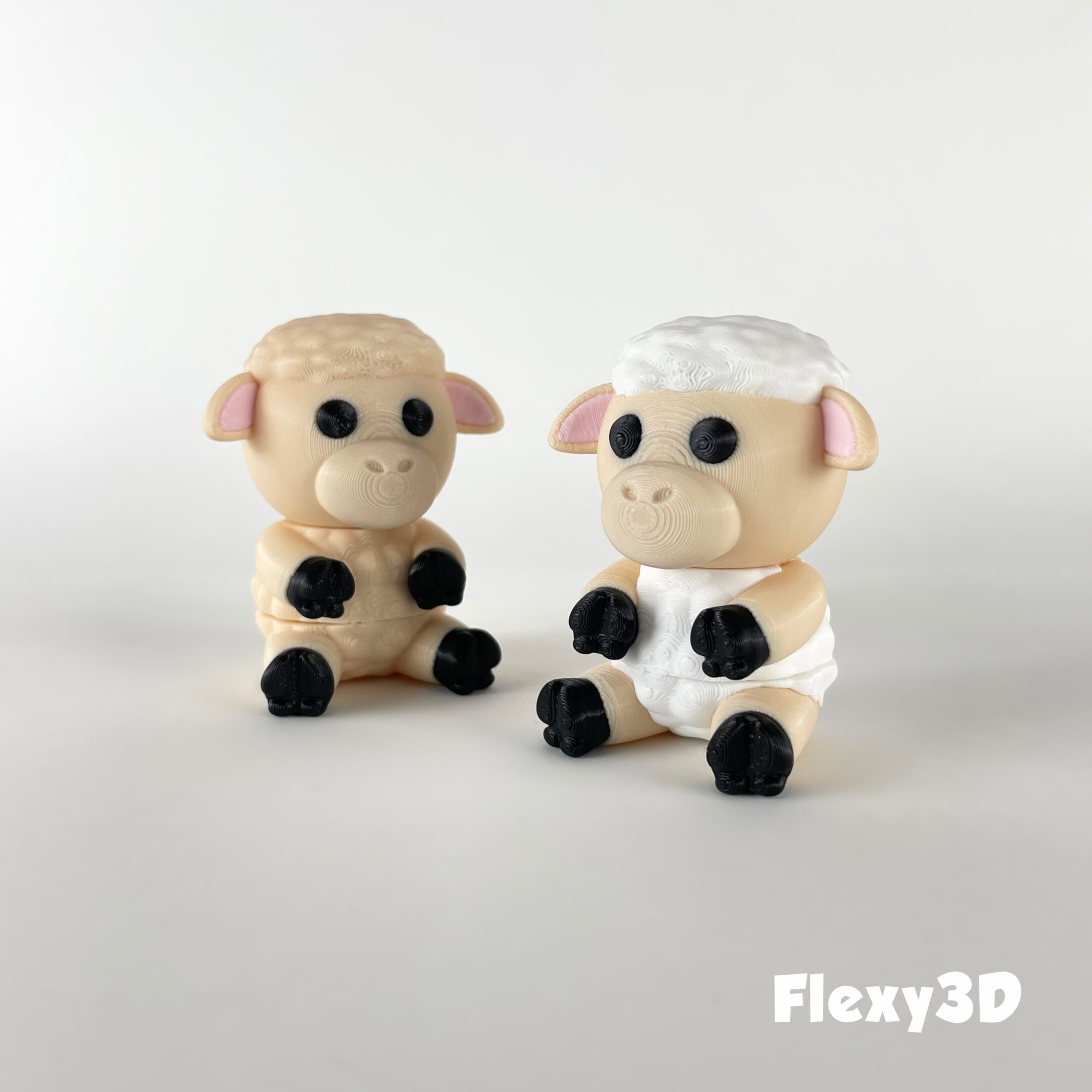 Two crocheted sheep toys, one cream and one white, sitting side by side.