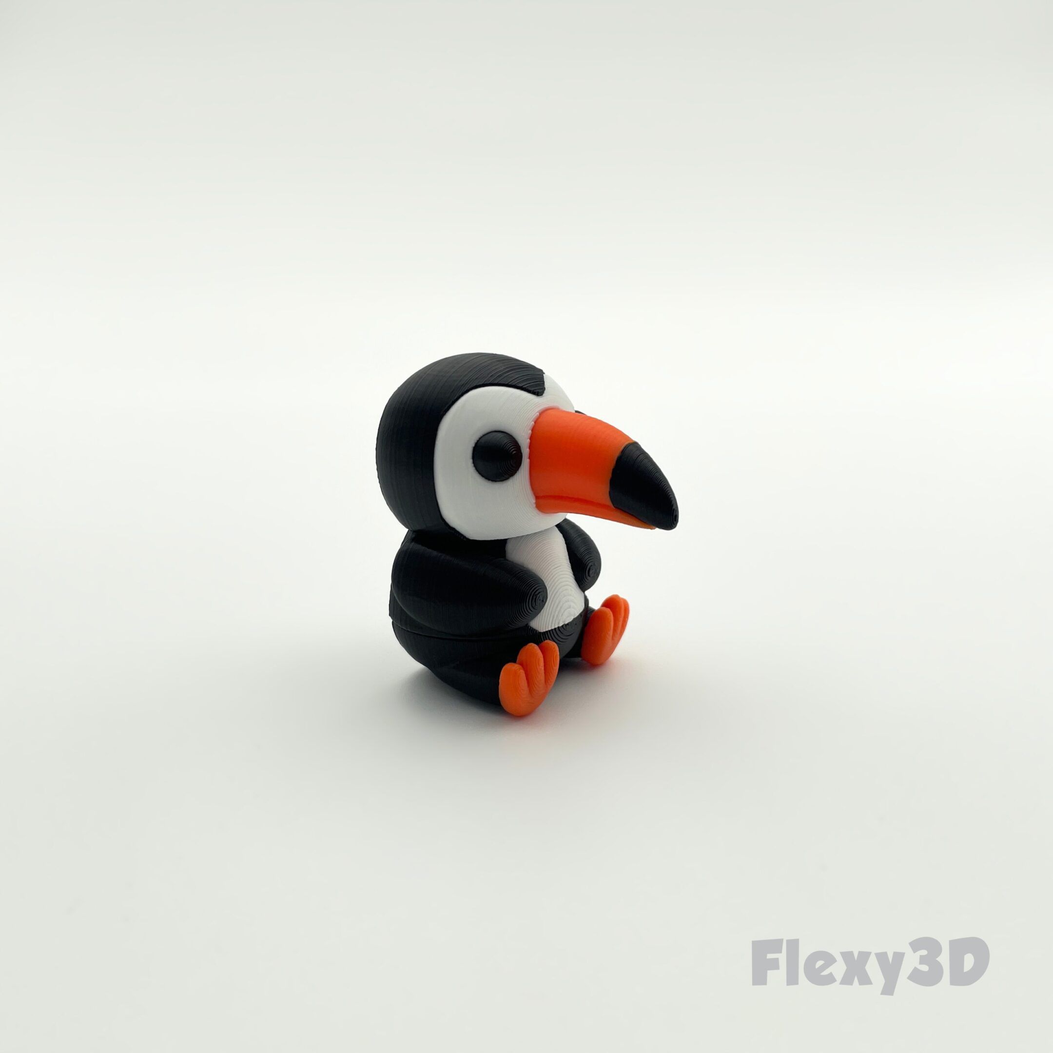 A small, cute toucan figurine with vibrant colors.