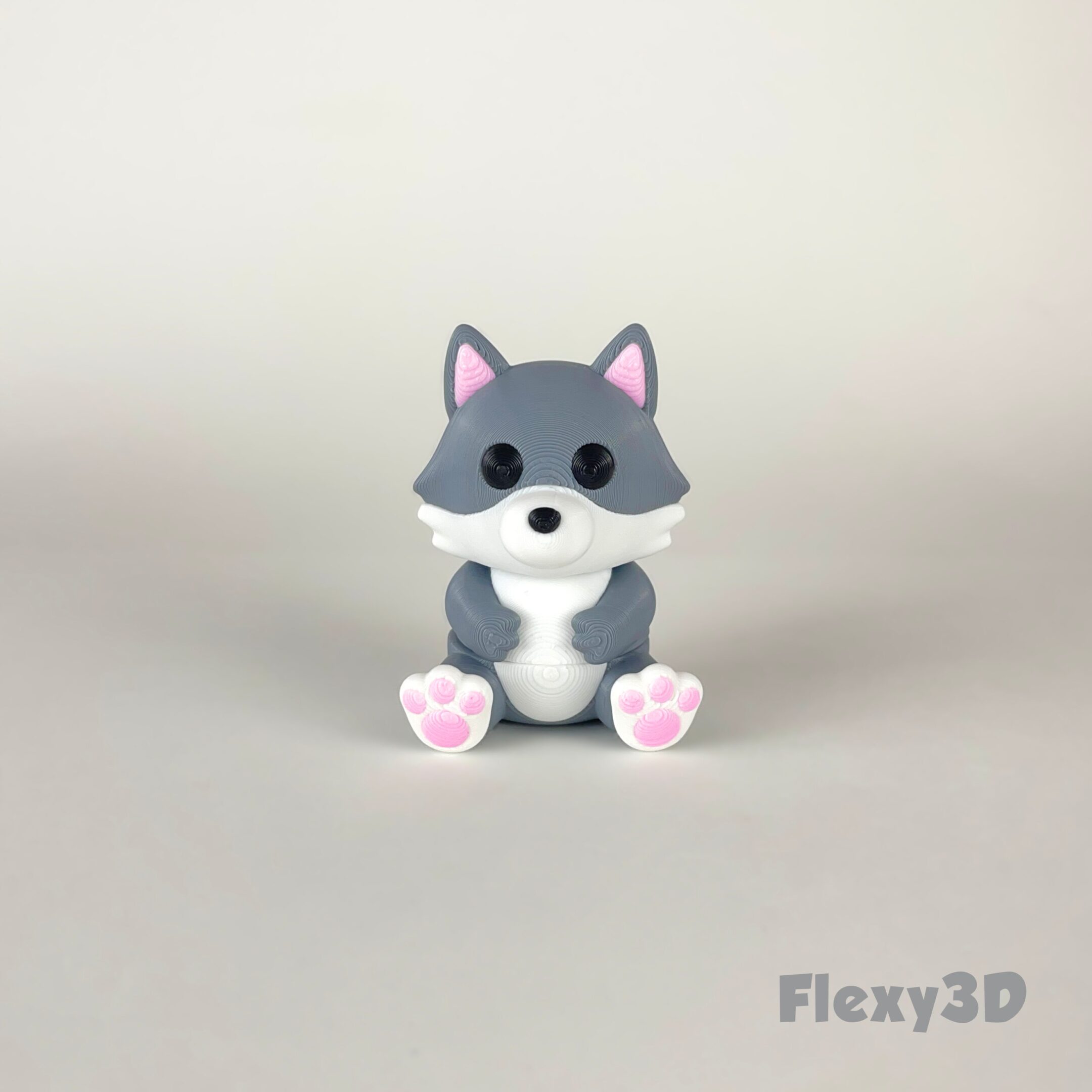 Cute gray and white wolf figurine with pink paws sitting.