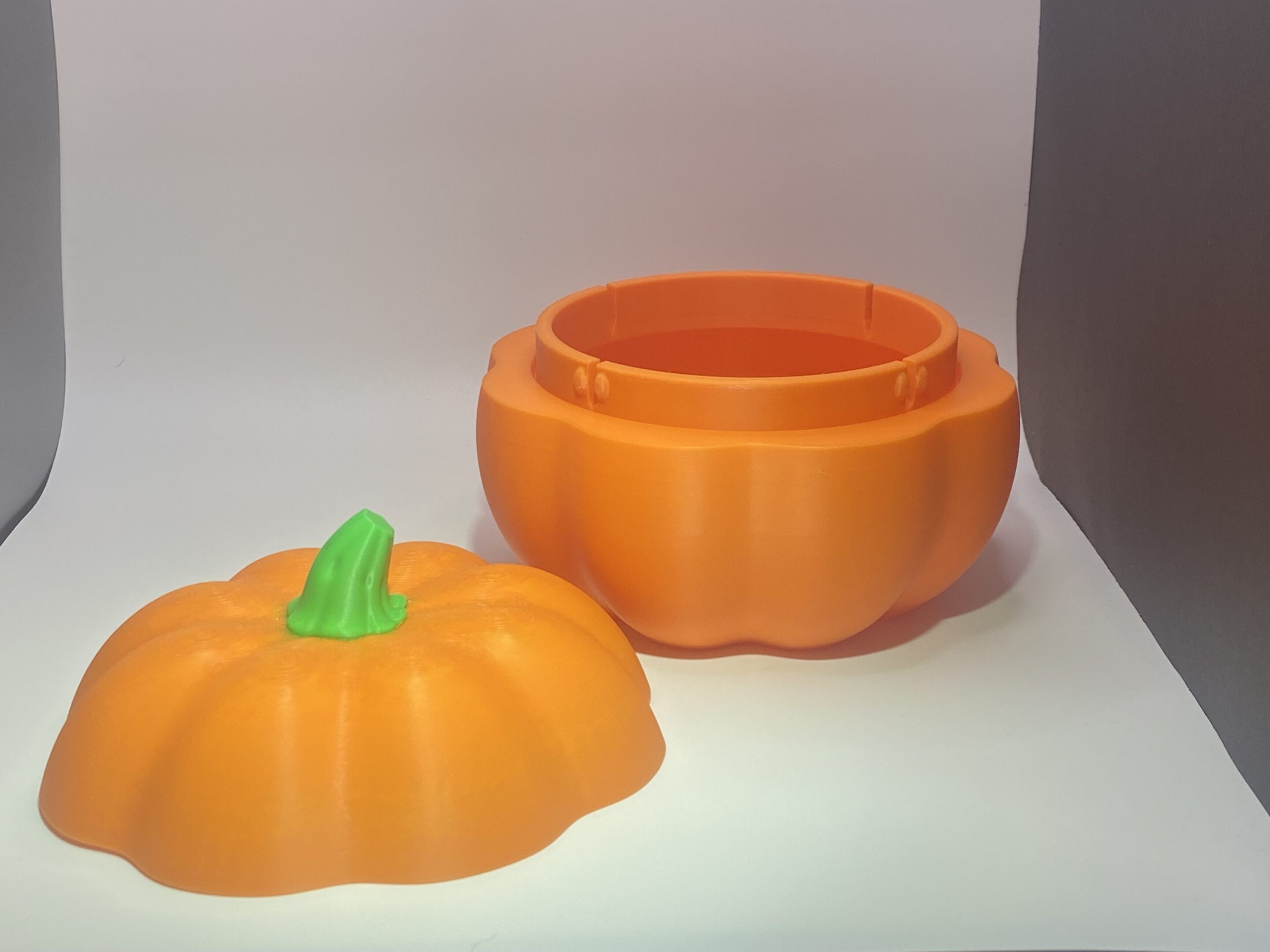 Orange plastic pumpkin container with removable lid.