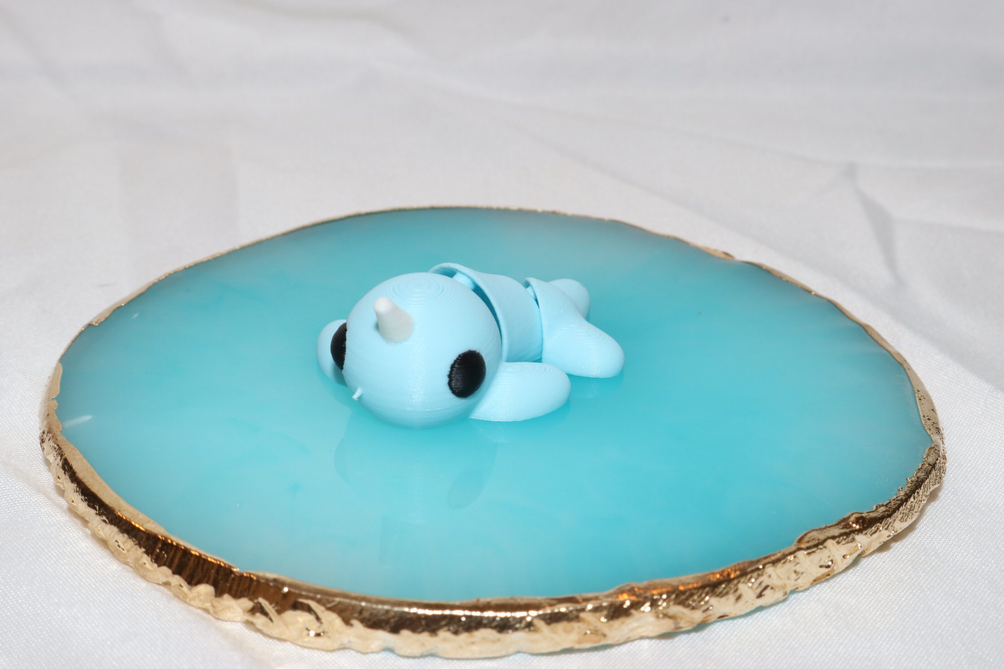 A cute blue fondant baby on a blue iced cake.