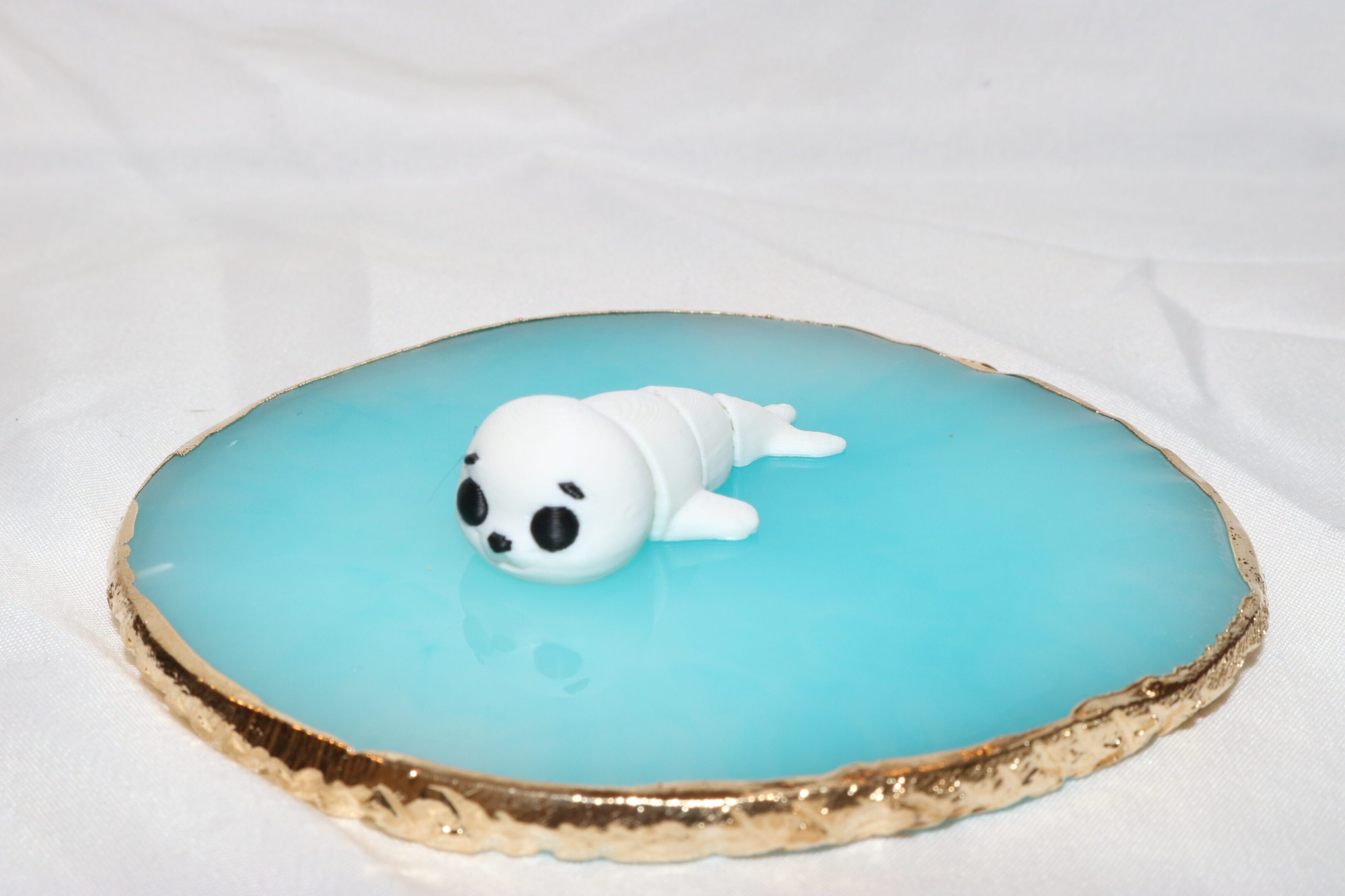 A cake decorated with a cute white seal on blue icing.