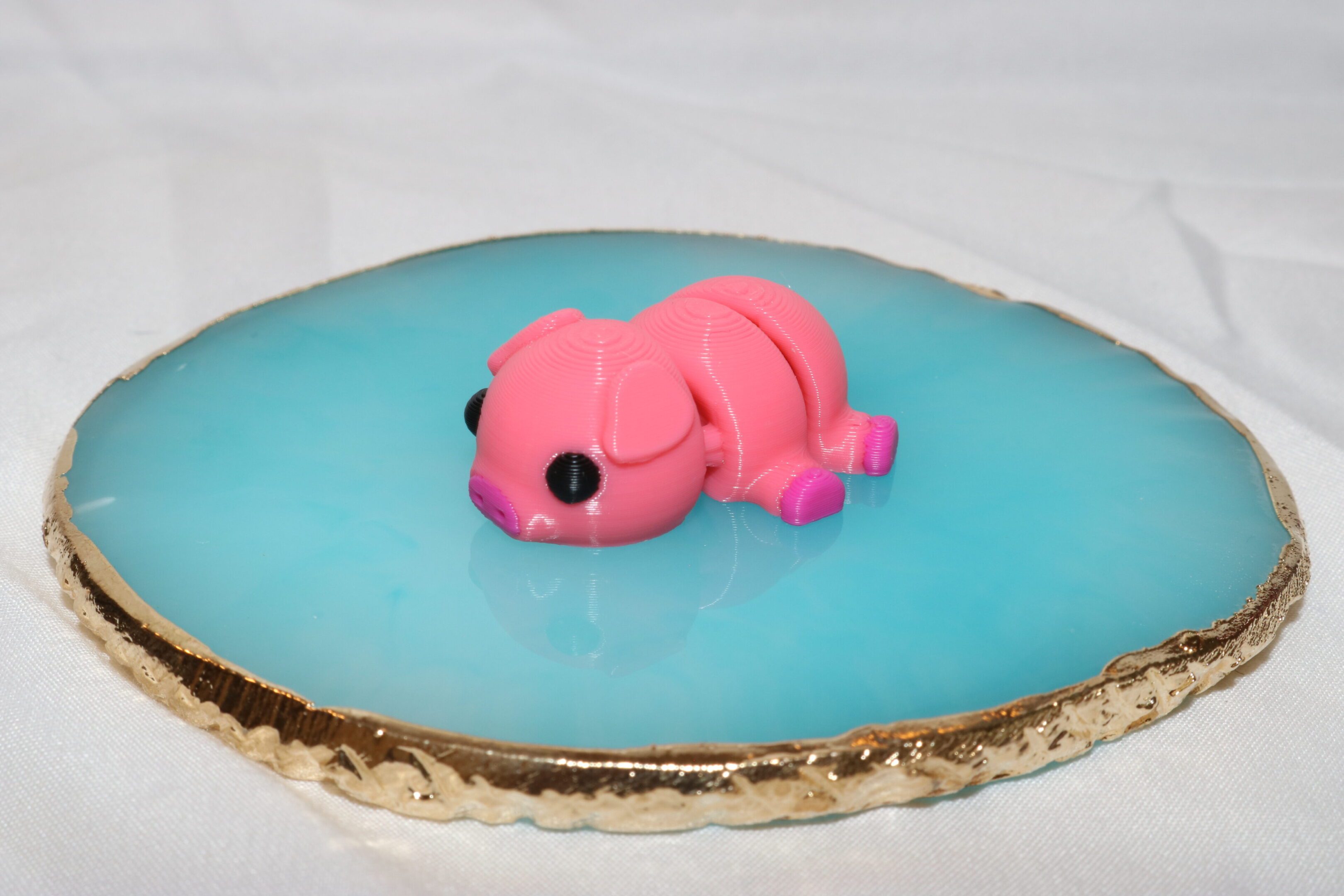 A pink frog-shaped dessert on a blue gelatin base.