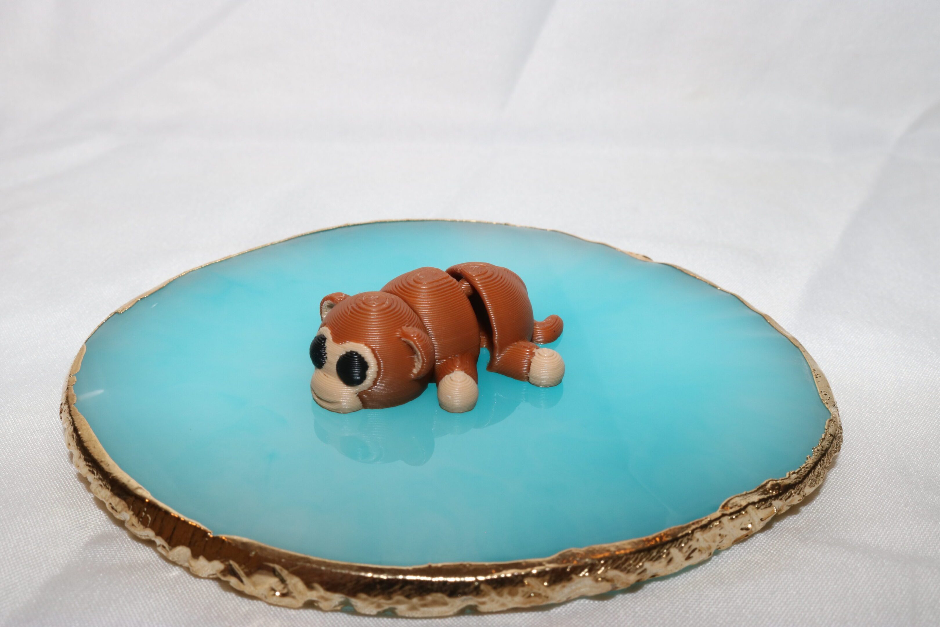 A cake topped with a fondant bear lying on blue icing.