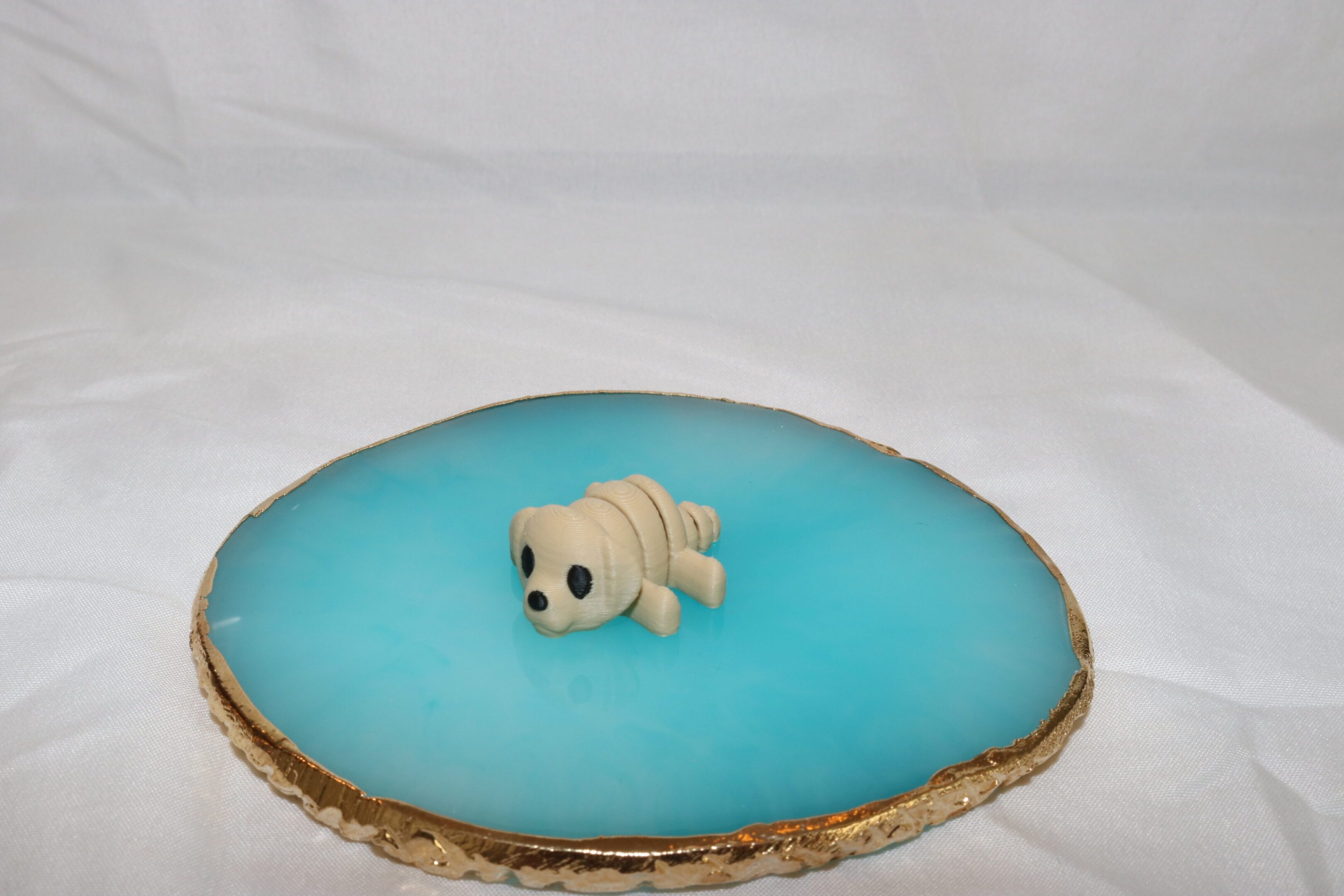 Small skull-shaped object on blue geode slice.