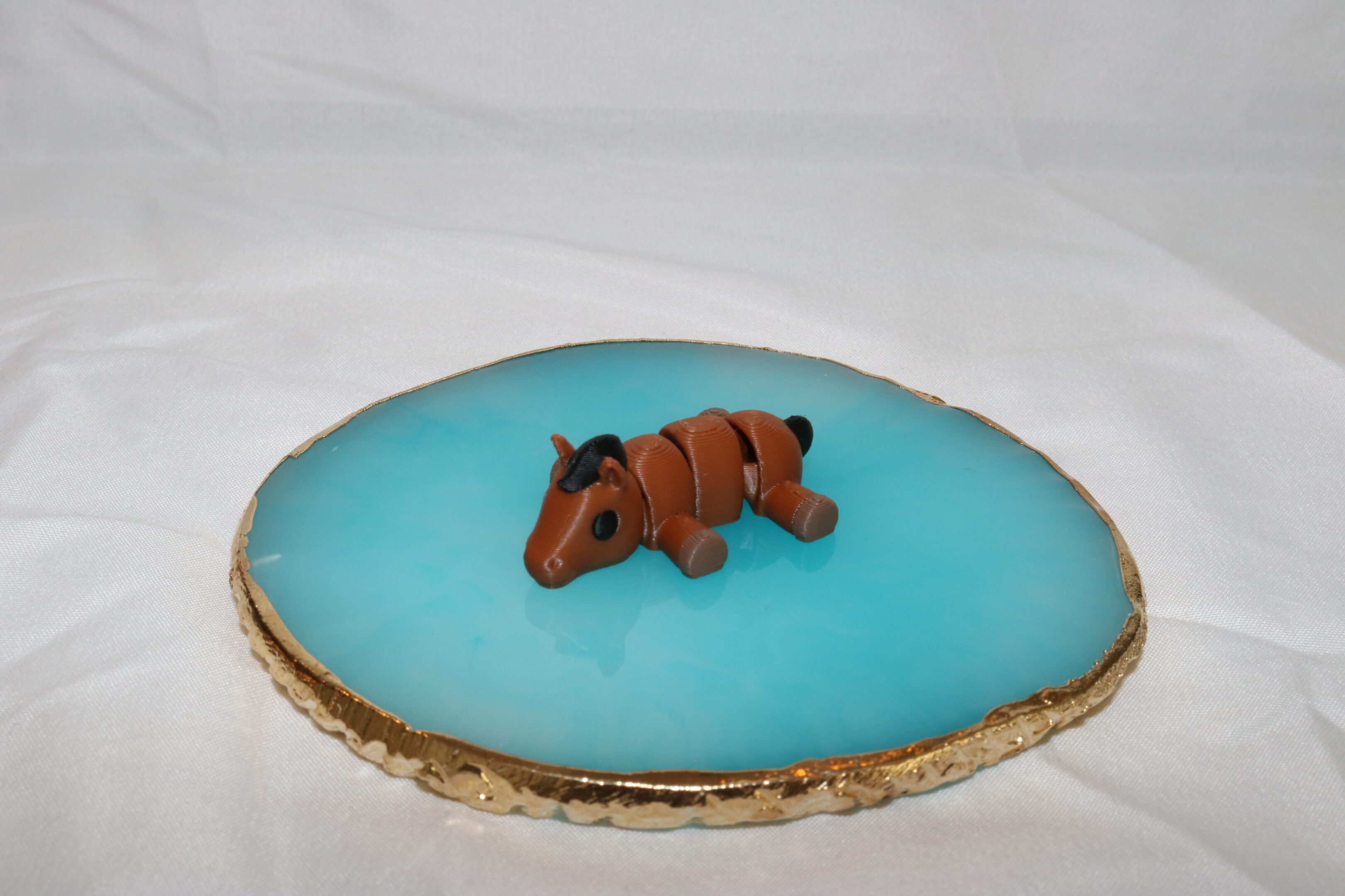 A small brown clay dog figurine on a blue surface.