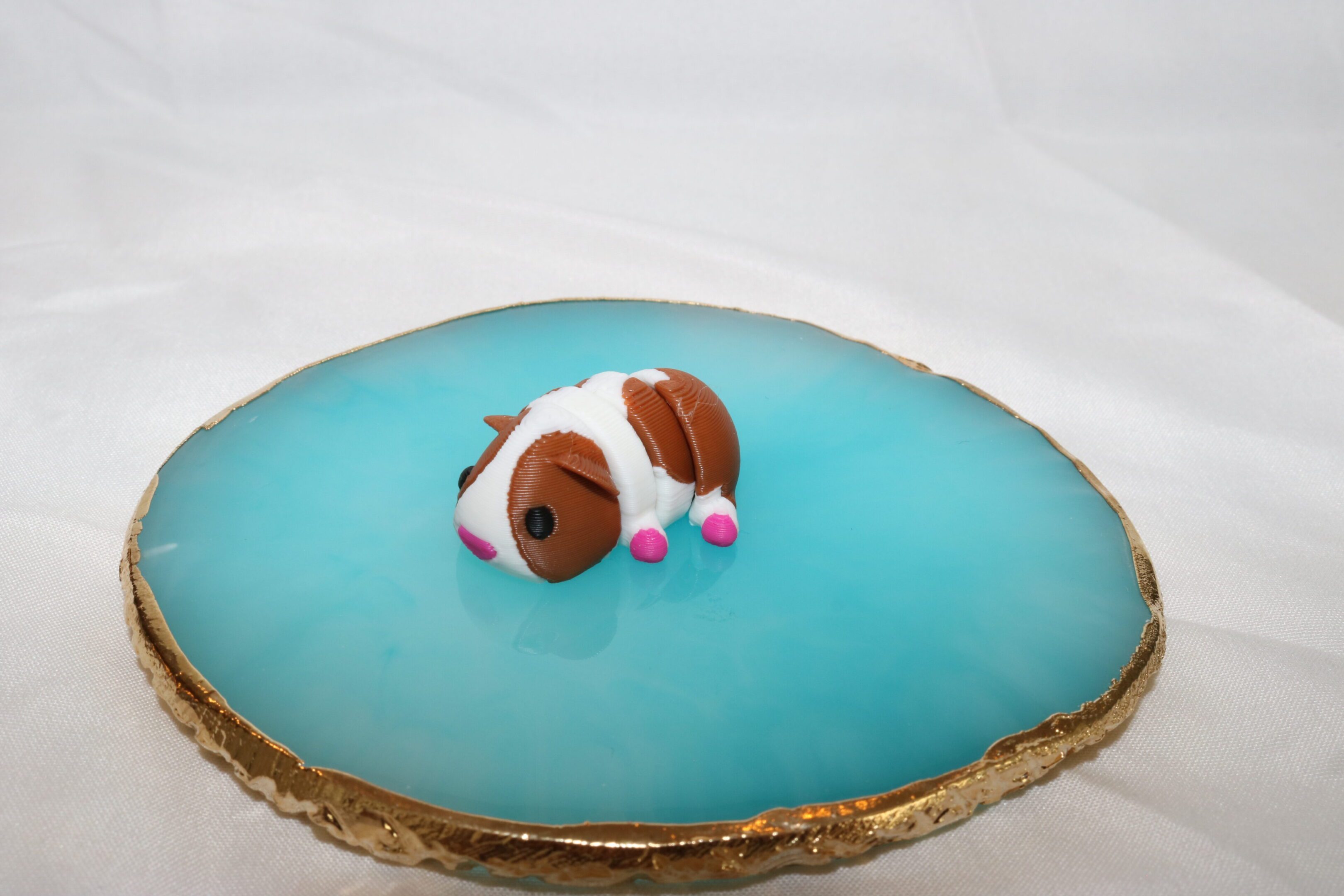A small, sleeping dog figurine on a smooth, blue geode surface.