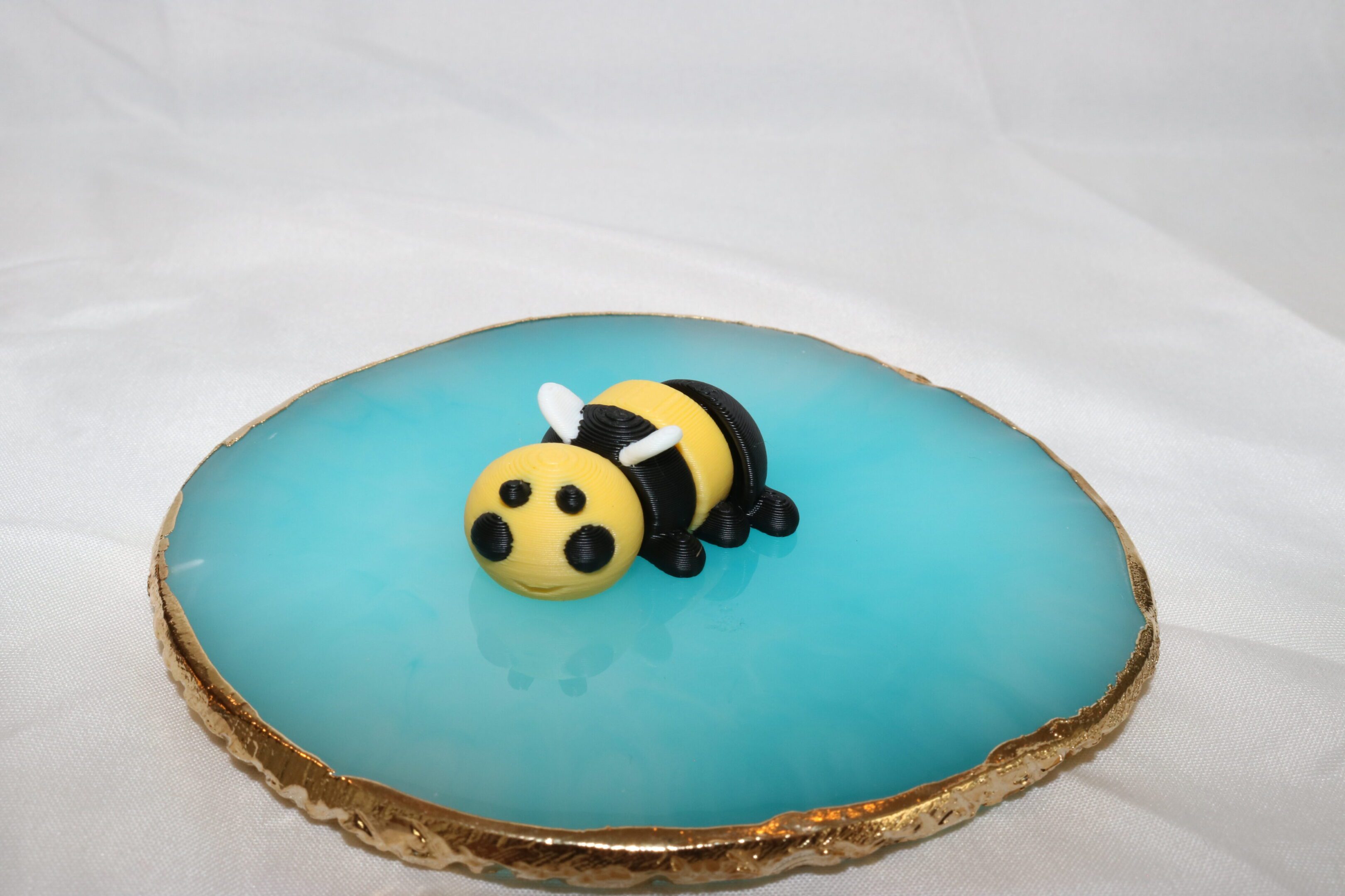 Cute bee-shaped cake on blue icing.