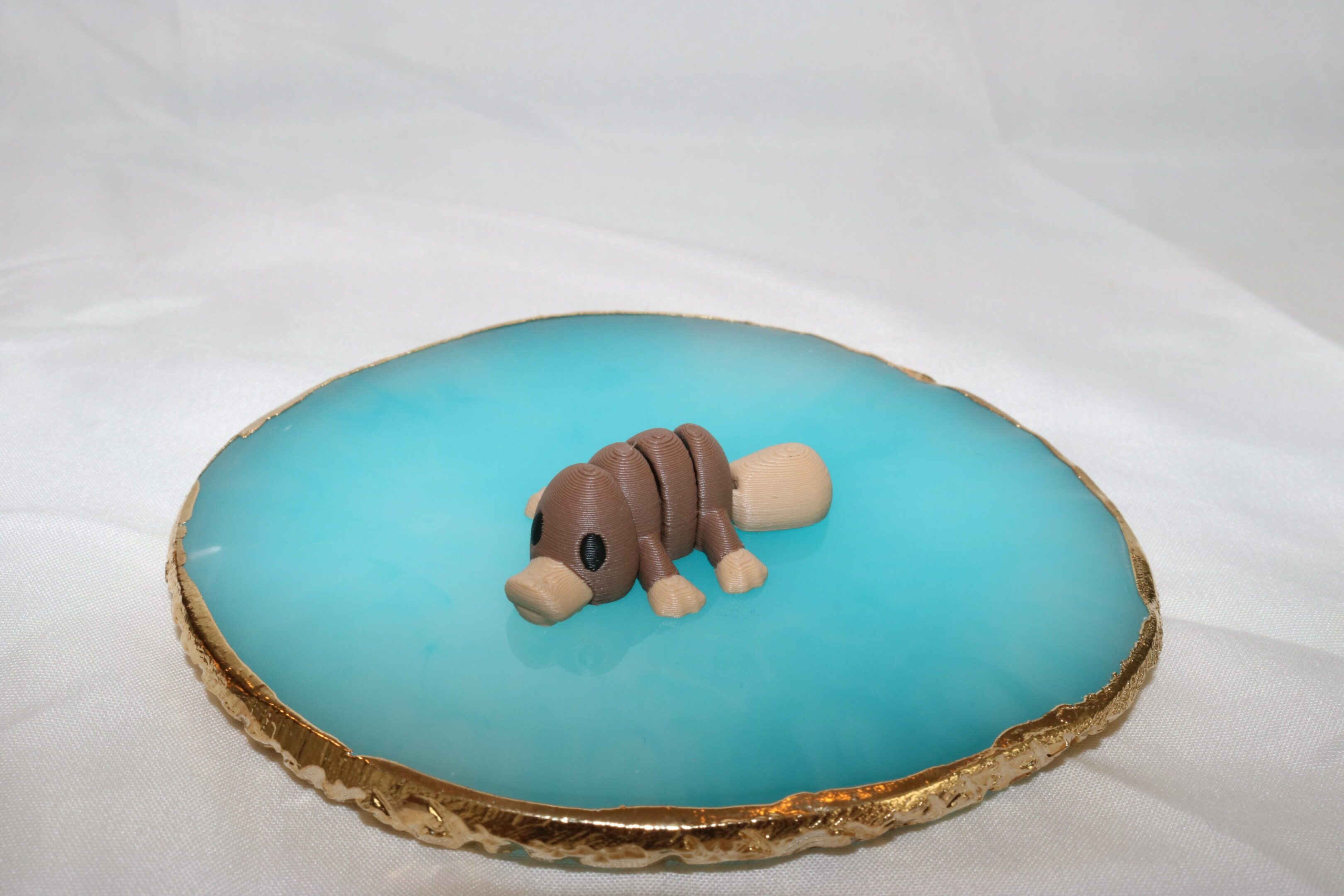 A small dog figurine on a blue surface with a textured base.