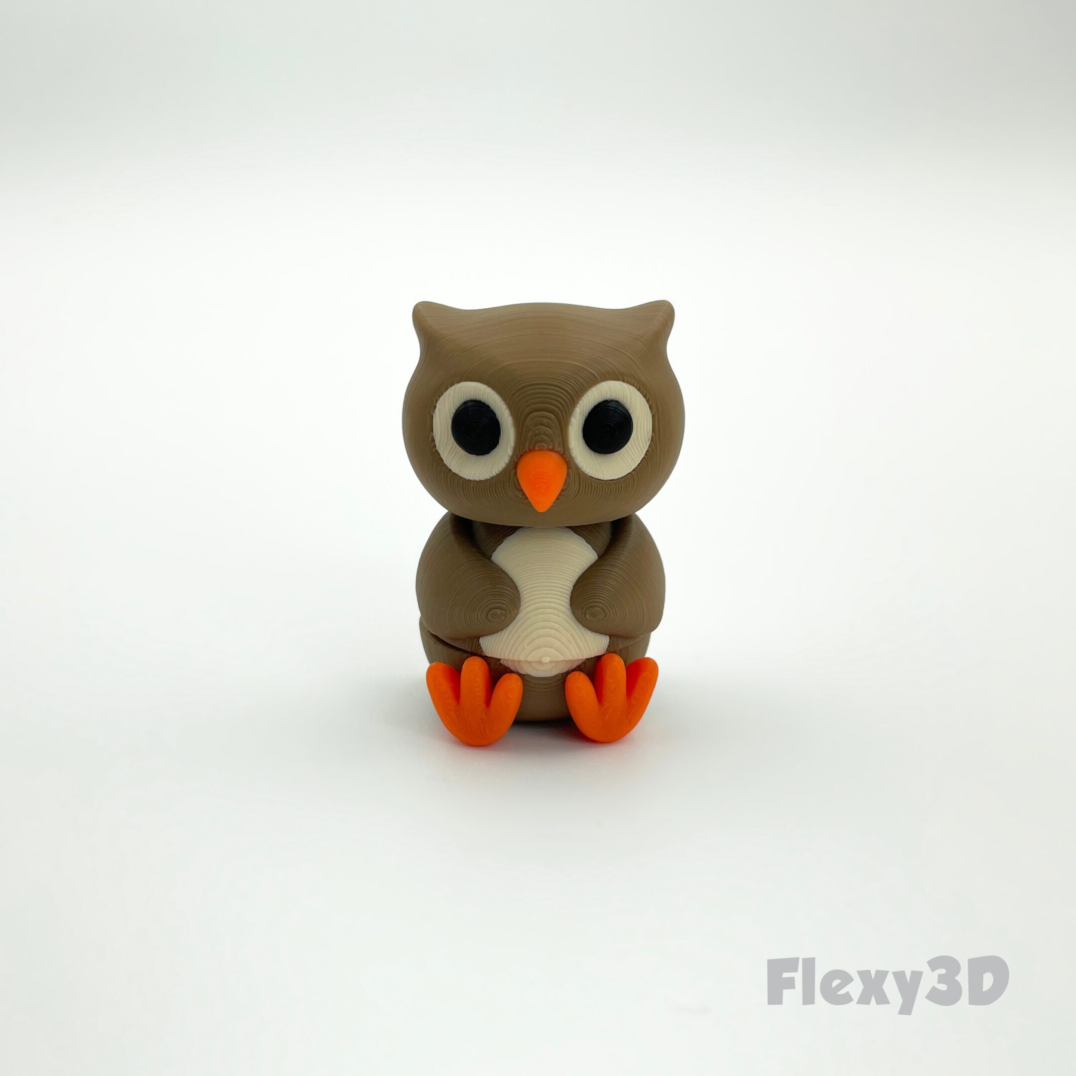 Small cute owl figurine with big eyes and orange feet.